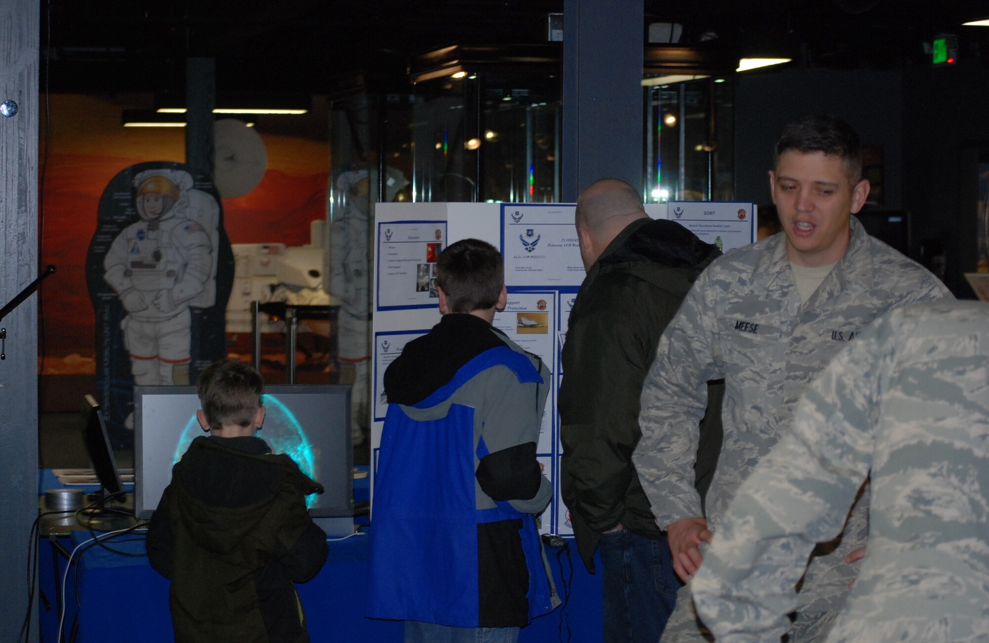 COLORADO SPRINGS, Colo. -- Visitors examine the 21st Operations Support Squadron Weather Flight display at the Space Foundation Star Days event March 7, while Staff Sgt. Randy Meese, 21st OSS weather technician, stands-by to answer questions from visitors. (U.S. Air Force photo by Dave Smith)