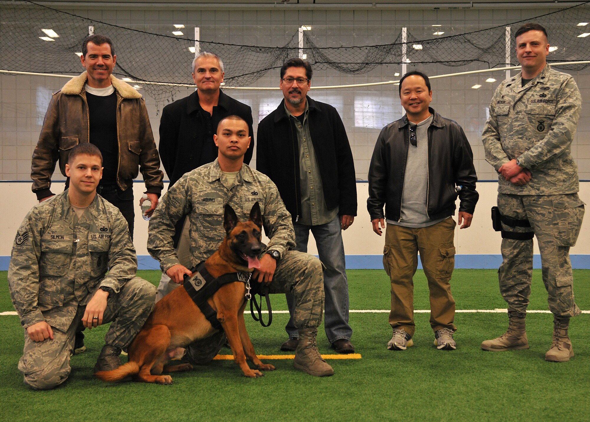(Far right) Lt. Col. Jeffery Becker, 319th Security Forces Squadron commander, poses with the comedians from the Comics on Duty Tour along with members of the 319th SFS Military Working Dog handlers during a tour around base on March 13, 2015, on Grand Forks Air Force Base, N.D. Throughout the day, the comedians visited multiple agencies on base showcasing the mission of the Warriors of the North. (U.S. Air Force photo/Senior Airman Xavier Navarro)