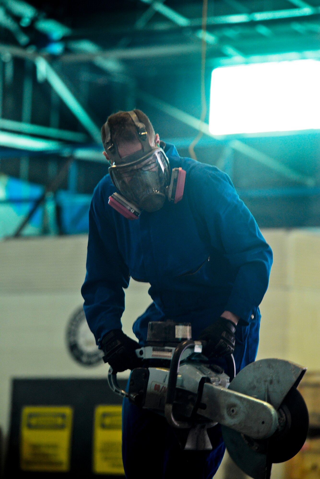 An Airman from the 5th Maintenance Squadron repair and reclamation section uses an electric saw to cut the vertical fin of a B-52H Stratofortress on Minot Air Force Base, N.D., Feb. 25, 2015. The fin is being cut for shipping purposes for thermal and blast testing. Thermal testing will look at the thermal response of coatings and material stack-ups to a pulse similar to a nuclear thermal pulse. Blast testing will be conducted at a future date looking into the structural response to an overpressure shockwave. The results will be used to update the nuclear hardness of the aircraft, which is used in models to produce Escape Distance Required Curves within Technical Order 25s. (U.S. Air Force photo/Senior Airman Brittany Y. Bateman)