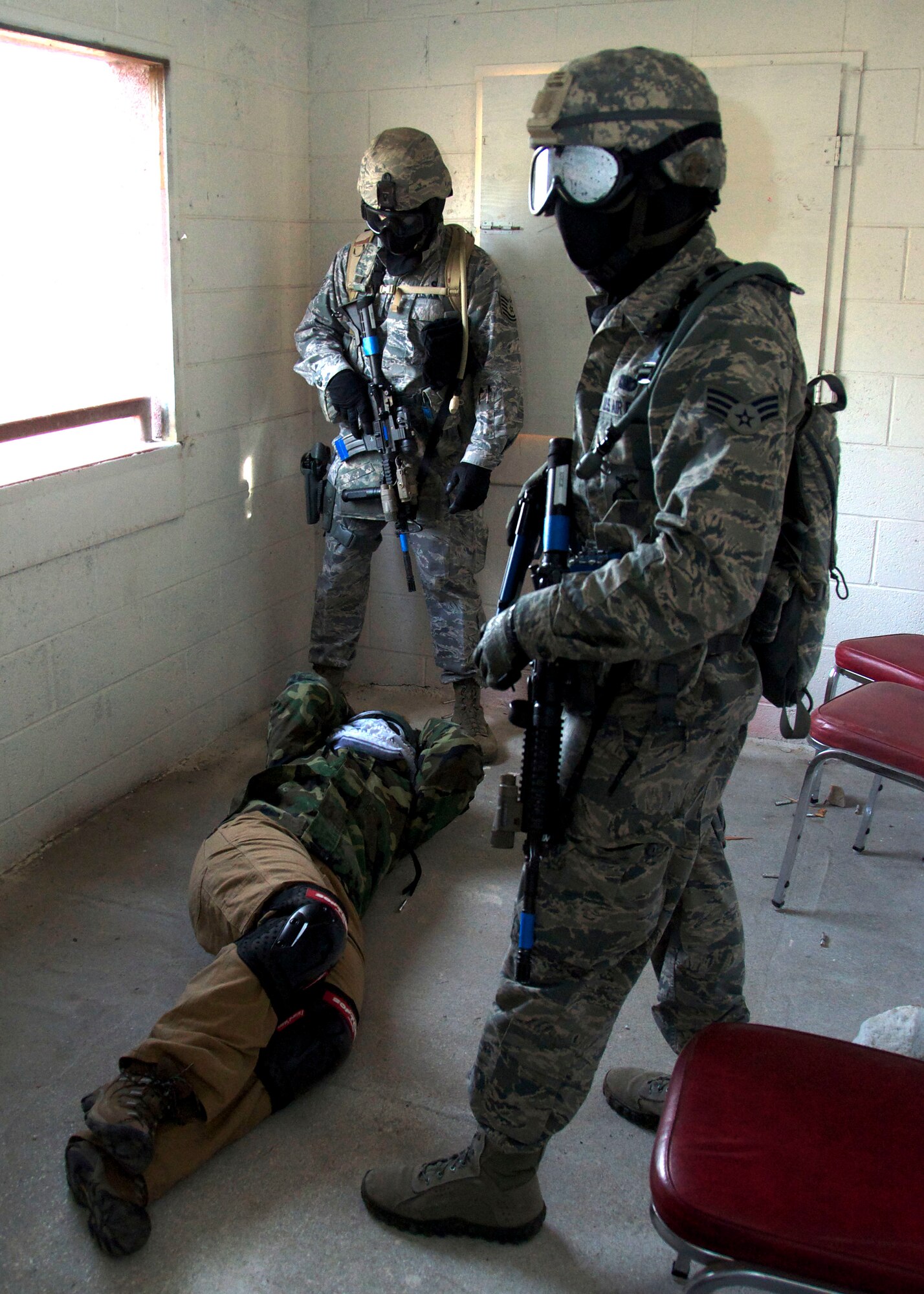 Tech. Sgt. Jason Eden and Senior Airman Tyler Hunter, 419th Security Forces Squadron, secure Tech. Sgt. Amanda Cespedes, services specialist in the 419th Services Flights, who plays the role of a “hostile.” All hostiles are medically evaluated, handcuffed, and searched for weapons or explosive devices before being escorted to a secure location away from the building. More than 50 reservists from the 419th Fighter Wing participated in the four-day training exercise at Camp Williams March 11-14. (U.S. Air Force photo/Staff Sgt. Crystal Charriere)