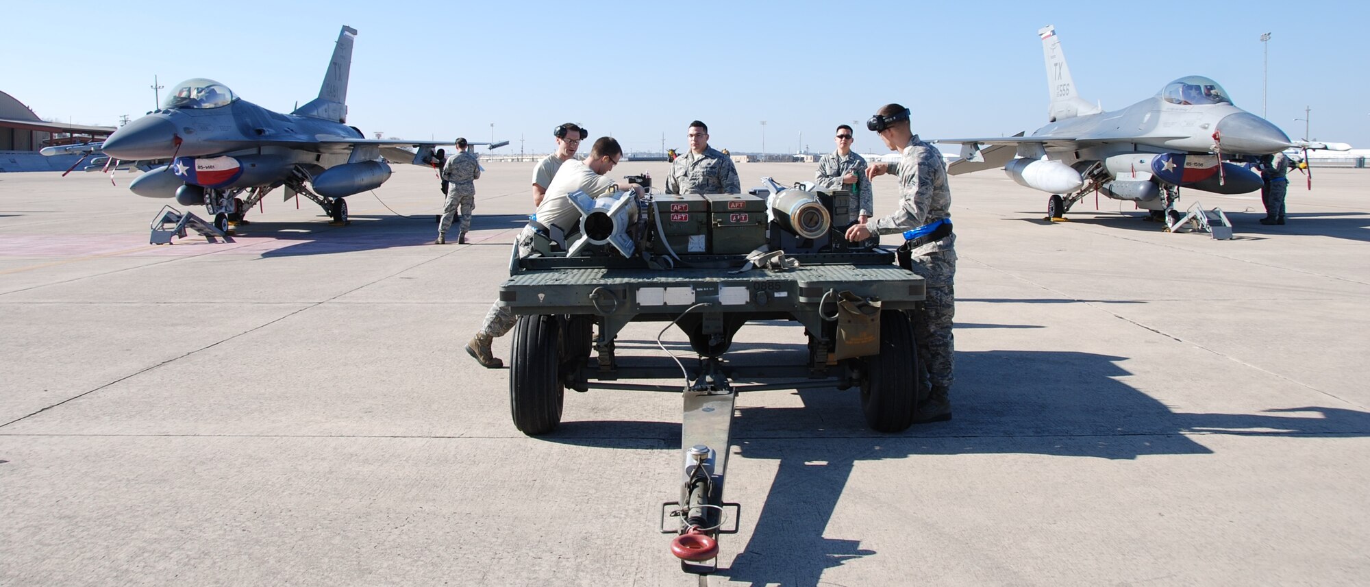 NAVAL AIR STATION FORT WORTH JOINT RESERVE BASE, Texas - 301st Fighter Wing Airmen complete their munitions prep before loading them on a F-16 Fighting Falcon during the annual weapons load competition here Feb. 8, 2015. Working side-by-side, active duty and Reserve Airmen towed, placed, and properly loaded four inert munitions onto each of the four F-16s in under 47 minutes. Three inspectors evaluated a crew on general knowledge test and munitions load. (U.S. Air Force photo/Staff Sgt. Melissa Harvey) 