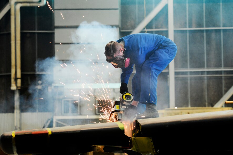 An Airman from the 5th Maintenance Squadron repair and reclamation section uses an electric saw to cut the vertical fin of a B-52H Stratofortress on Minot Air Force Base, N.D., Feb. 25, 2015. The fin is being cut for shipping purposes for thermal and blast testing. Thermal testing will look at the thermal response of coatings and material stack-ups to a pulse similar to a nuclear thermal pulse. Blast testing will be conducted at a future date looking into the structural response to an overpressure shockwave. The results will be used to update the nuclear hardness of the aircraft, which is used in models to produce Escape Distance Required Curves within Technical Order 25s. (U.S. Air Force photo/Senior Airman Brittany Y. Bateman)