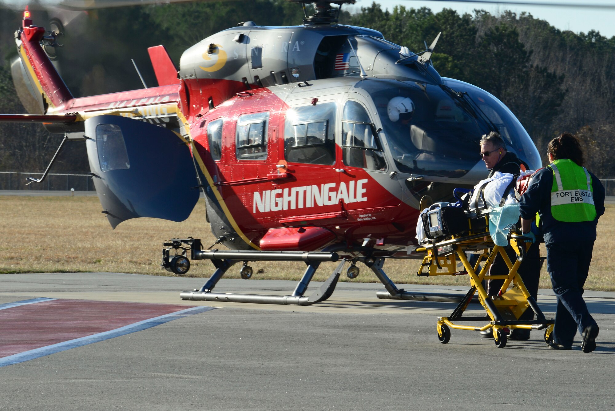 Emergency responders from the McDonald Army Health Center Installation Support Team and Sentara Norfolk General Hospital simulate transporting a patient to a medical evacuation helicopter during a full-scale helicopter crash exercise at Fort Eustis, Va., March 13, 2015. As part of the exercise, the medical helicopter was called in from the 733rd Civil Engineer Division Fire Department to assist them with a simulated critical patient. (U.S. Air Force photo by Senior Airman Kimberly Nagle/Released)