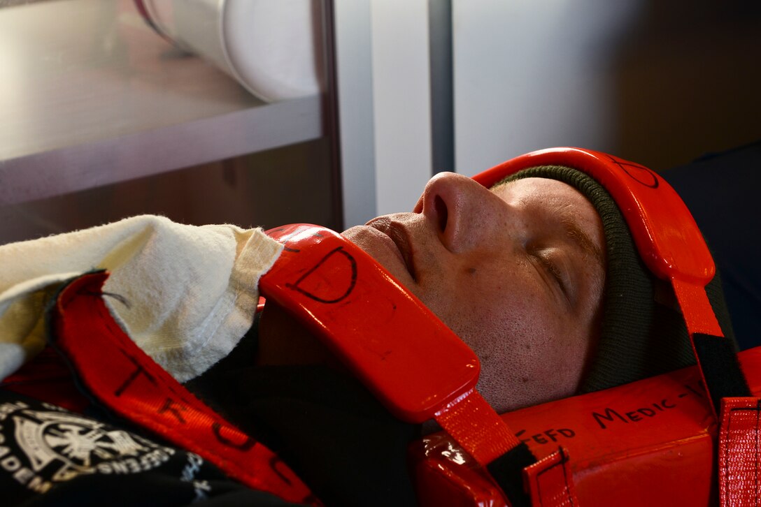 Maurice Carter, 733rd Civil Engineer Division firefighter, is transported by ambulance during a full-scale helicopter crash exercise at Fort Eustis, Va., March 13, 2015. Carter was also transported in a medical evacuation helicopter, Nightingale, due to his simulated critical injuries. (U.S. Air Force photo by Senior Airman Kimberly Nagle/Released)