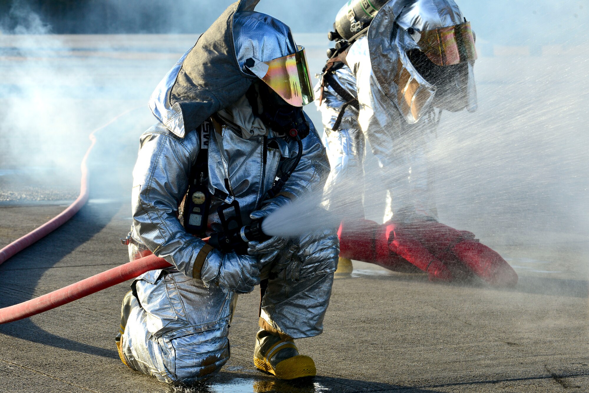 Firefighters from the 733rd Civil Engineer Division Fire Department respond to a full-scale helicopter crash exercise at Fort Eustis, Va., March 13, 2015. The firefighters were the first on scene to begin searching for casualties and to put out simulated flames coming from the helicopter. (U.S. Air Force photo by Senior Airman Kimberly Nagle/Released)