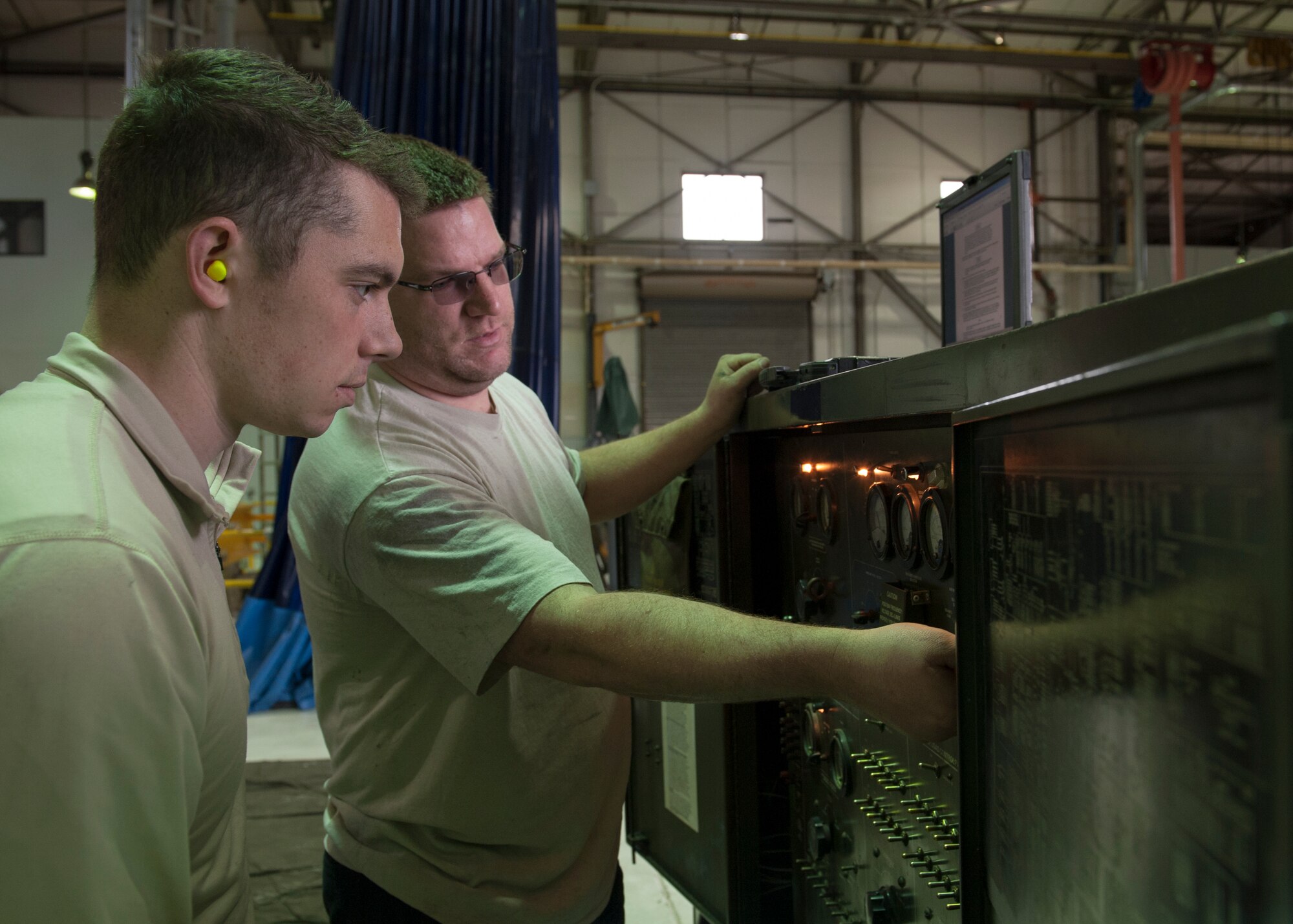 Chris Davis, 436th Maintenance Squadron Aerospace Ground Equipment mechanic, instructs Airman 1st Class Chancellor Mackey, 436th MXG AGE apprentice, March 17, 2015, at Dover Air Force Base, Del. The AGE Flight is responsible for maintaining a wide verity of ground equipment, primarily used on Team Dover’s flight line. (U.S. Air Force photo/Airman 1st Class Zachary Cacicia)