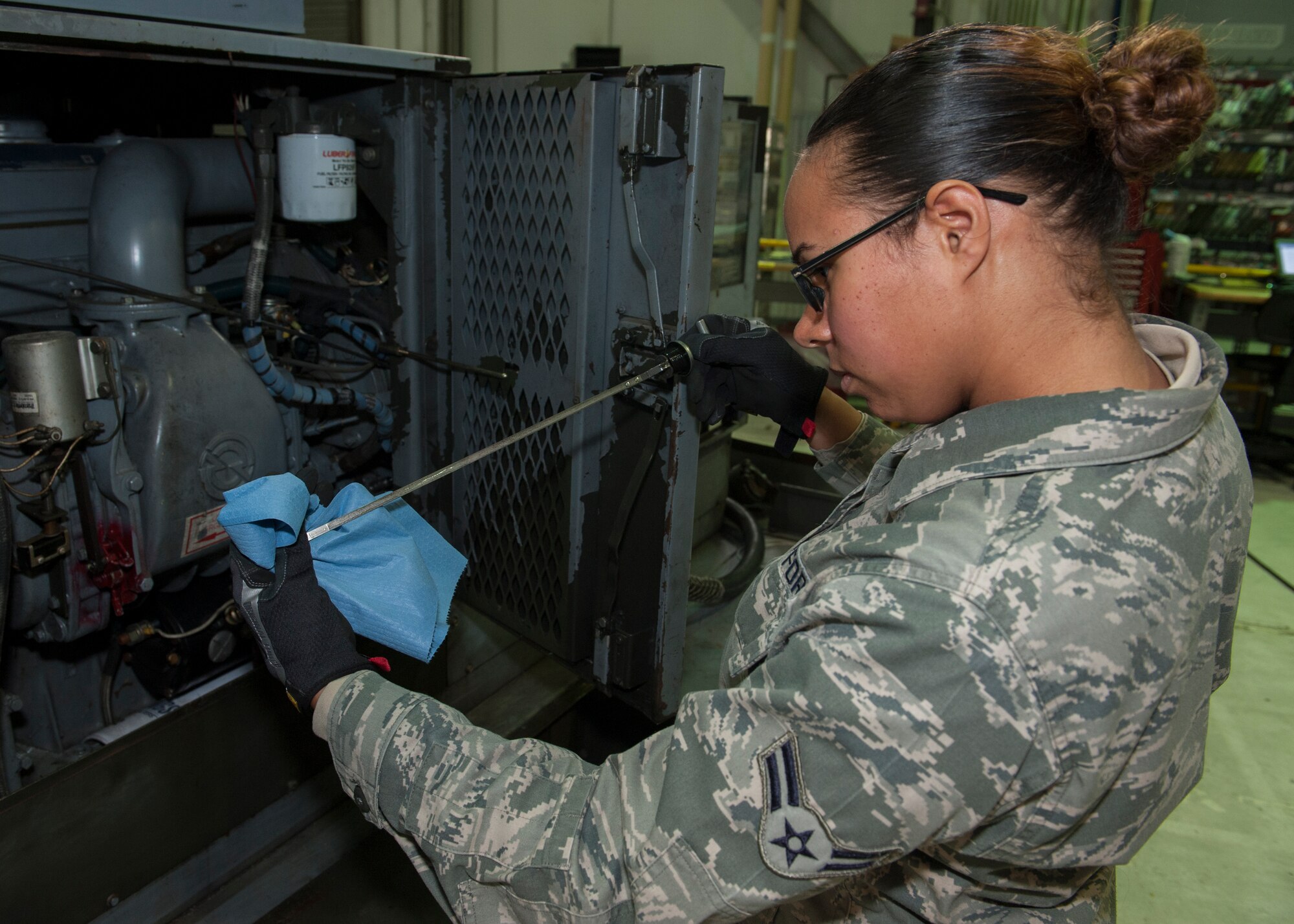 Airman 1st Class Desiree Klein, 436th Maintenance Squadron Aerospace Ground Equipment apprentice, checks the oil level of a portable generator March 17, 2015, at Dover Air Force Base, Del. The AGE Flight is comprised of Airmen from both the active duty 436th Airlift Wing and the Reserve 512th AW. (U.S. Air Force photo/Airman 1st Class Zachary Cacicia)