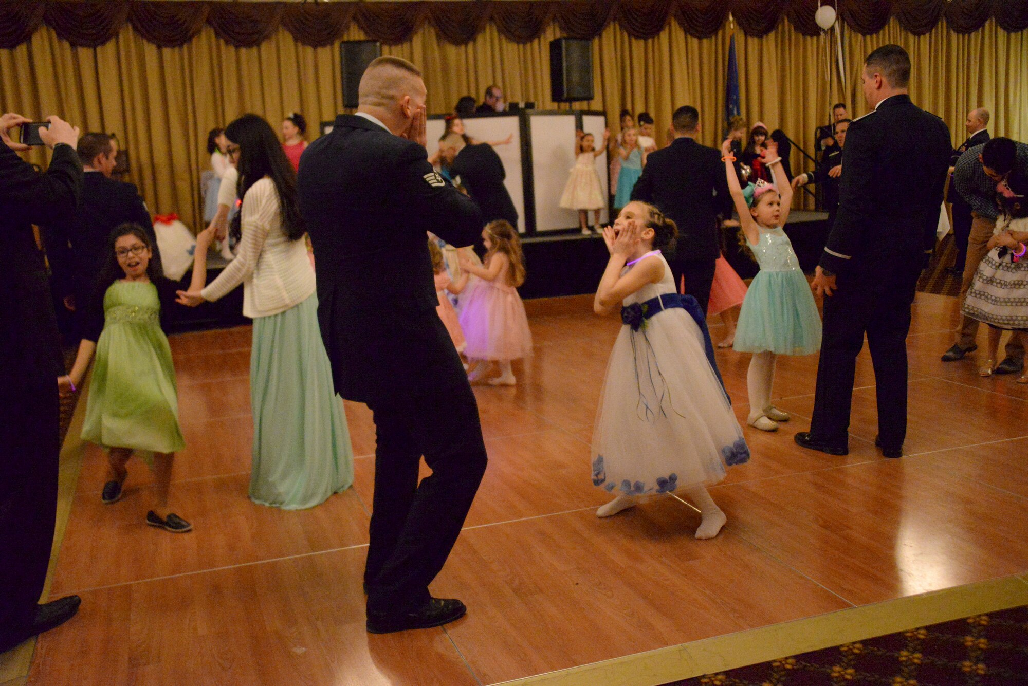 Fathers and daughters let loose on the dance floor during the Annual Princess and Her Hero Dance at Tommy B’s Community Activities Center on Joint Base McGuire-Dix-Lakehurst, N.J., March 13, 2015. The dance gave fathers and daughters alike to dress up and share a special evening together. (U.S. Air Force photo by Airman 1st Class Tara A. Williamson/Released)
