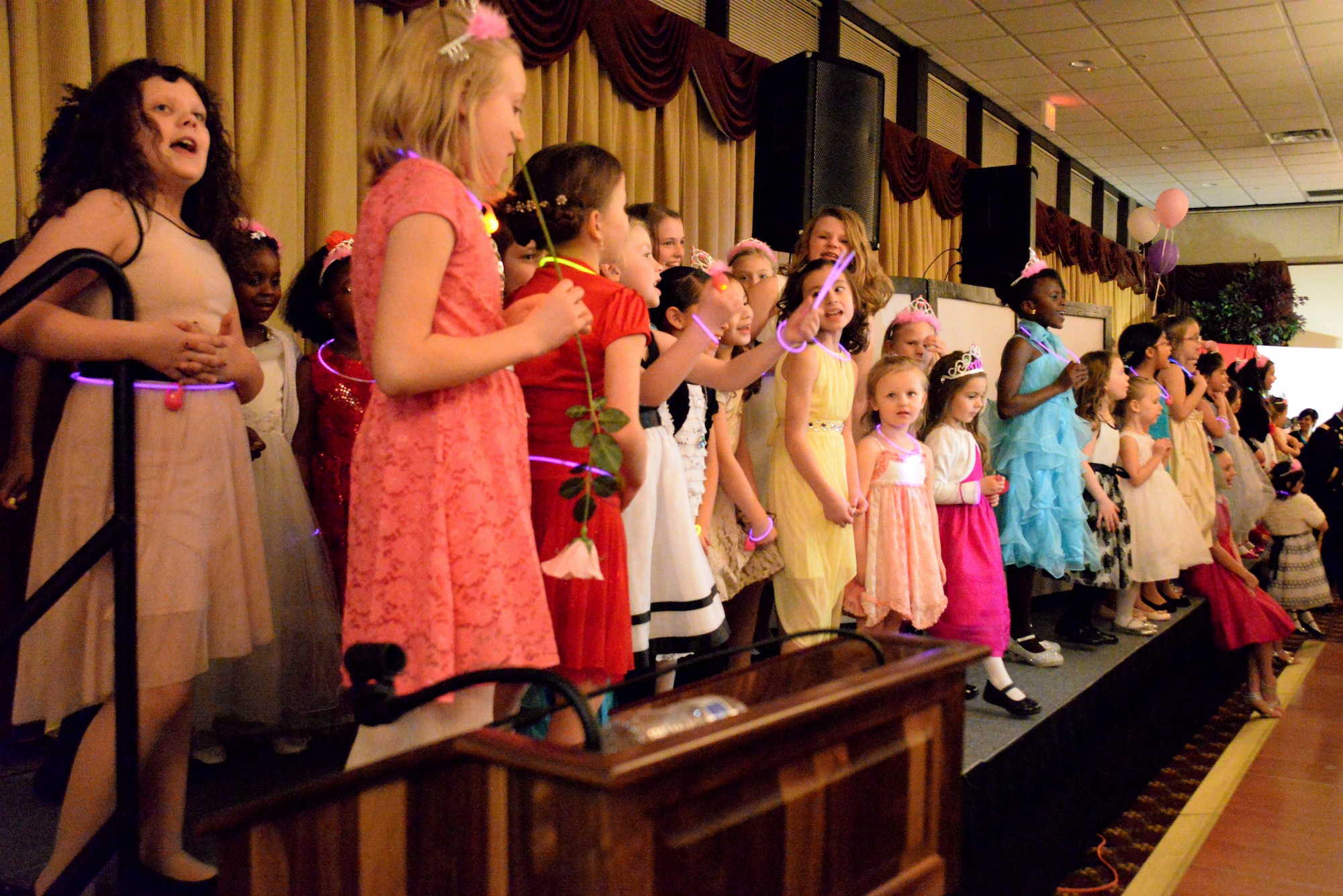 Girls gather on stage to sing the popular Disney song “Let It Go” during the Annual Princess and Her Hero Dance at Tommy B’s Community Activities Center on Joint Base McGuire-Dix-Lakehurst, N.J., March 13, 2015. The event included a disc jockey, party favors, a photographer, crafts, refreshments and a special flower presented by the fathers. (U.S. Air Force photo by Airman 1st Class Tara A. Williamson/Released)