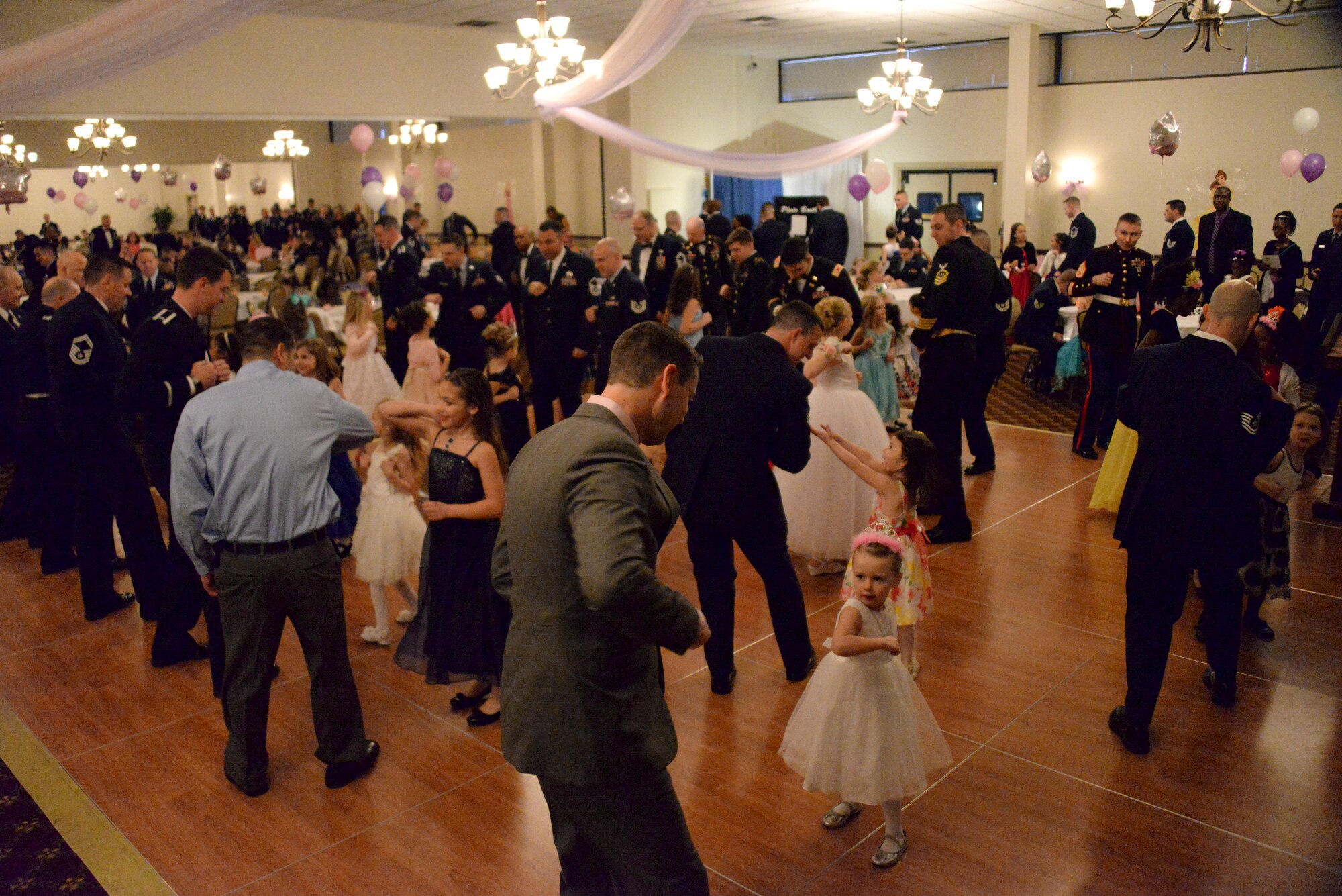 Fathers and daughters gather to dance “The Hokey Pokey” during the Annual Princess and Her Hero Dance at Tommy B’s Community Activities Center on Joint Base McGuire-Dix-Lakehurst, N.J., March 13, 2015. The event included a disc jockey, party favors, a photographer, crafts, refreshments and a special flower presented by the fathers. (U.S. Air Force photo by Airman 1st Class Tara A. Williamson/Released)