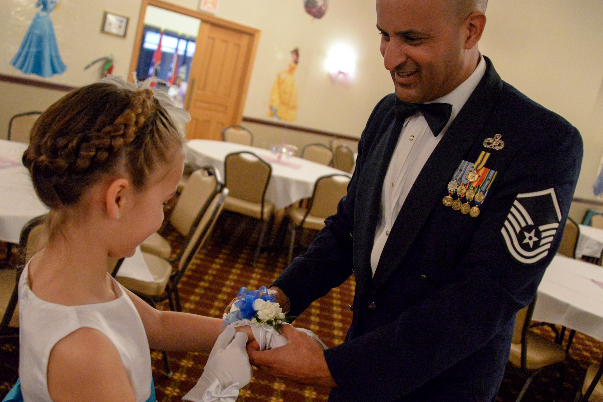 Master Sgt. Luca Dudley, Air Mobility Command Test and Evaluation Squadron senior test director, gives his daughter Bianca, 6, a corsage at the Annual Princess and Her Hero Dance at Tommy B’s Community Activities Center on Joint Base McGuire-Dix-Lakehurst, N.J., March 13, 2015. The dance gave fathers and daughters alike to dress up and share a special evening together. (U.S. Air Force photo by Airman 1st Class Tara A. Williamson/Released)