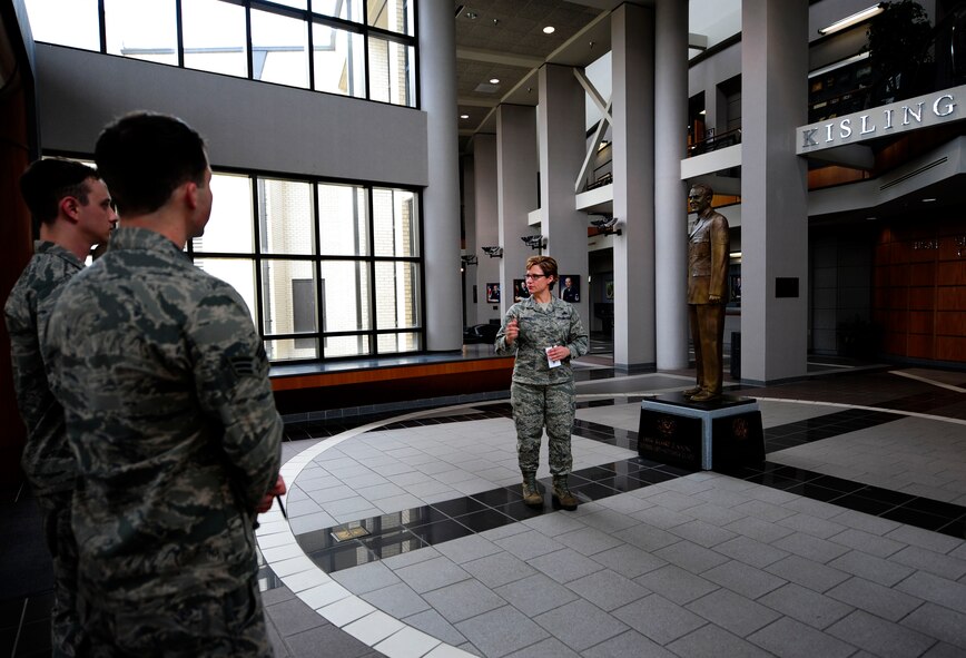 Senior Master Sgt. Hayden Pickett, Senior NCO Academy chief of programs and resources, showcases the statue of former Chief Master Sgt. of the Air Force Richard Kisling during a tour of the academy for junior enlisted Airmen, March 12, 2015, Maxwell-Gunter Air Force Base, Alabama.  The academy provides senior NCOs with current and highly effective military education in areas of advanced leadership and management. Kisling was the third chief master sergeant of the Air Force, and the Academy’s auditorium is named in his honor. (U.S. Air Force photo by Airman 1st Class Alexa Culbert/Cleared)