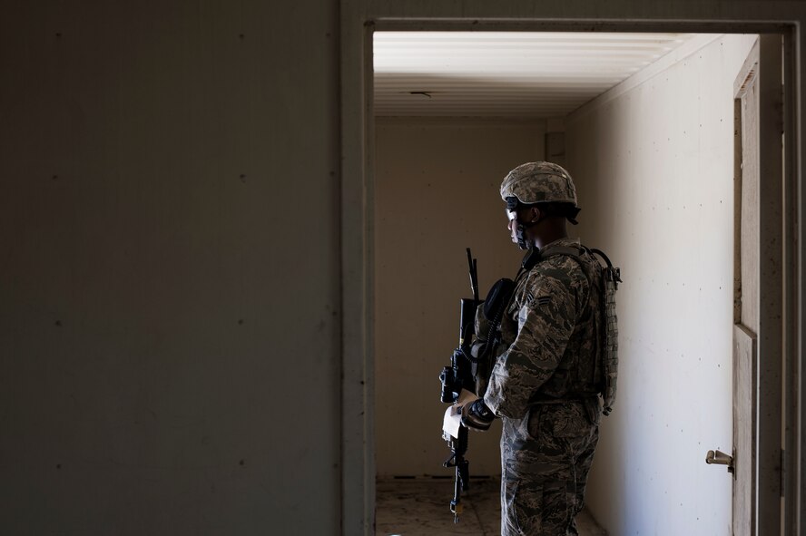 U.S. Air Force Senior Airman Montavious Harris, 824th Base Defense Squadron fireteam member, looks out the door of a building while pulling security during a mission readiness exercise March 10, 2015, at Camp Blanding, Fla. Each security team is responsible for scanning a section of the base perimeter for threats. (U.S. Air Force Photo by Senior Airman Ryan Callaghan/Released)

