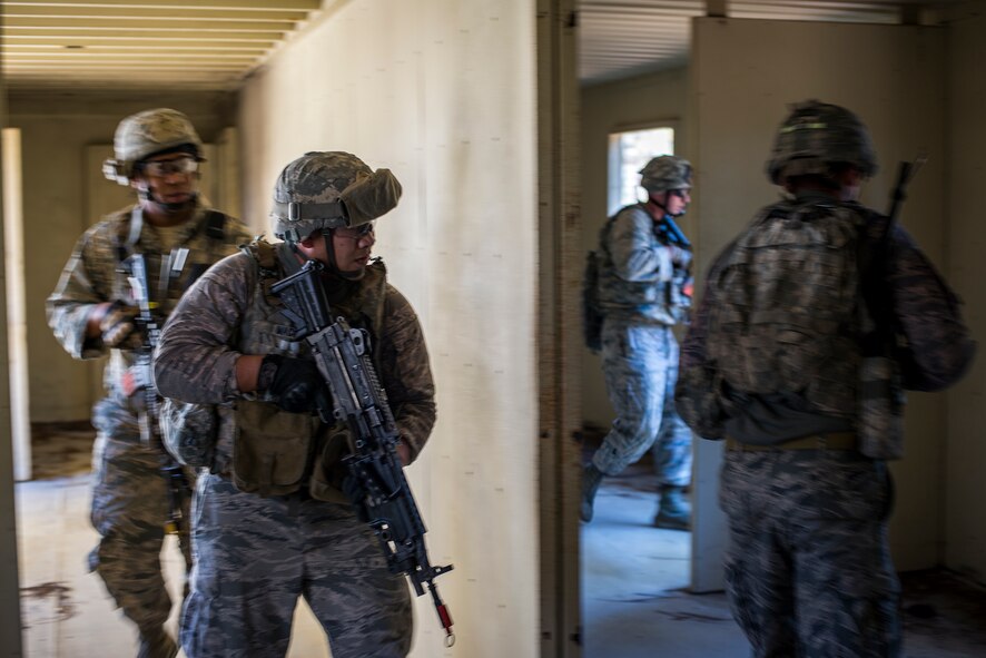 Fireteam members from the 824th Base Defense Squadron clear a building during a mission readiness exercise March 10, 2015, at Camp Blanding, Fla. Once the Airmen have cleared a building they mark it by leaving behind a glow stick. (U.S. Air Force Photo by Senior Airman Ryan Callaghan/Released)
