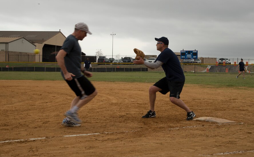 U.S. Air Force Chief Master Sgt. David Kelch (right), stands ready to catch the ball on first base after a ground hit March 13, 2015, at Moody Air Force Base, Ga. Every year Team Moody commanders and chiefs compete in a friendly softball match against each other. (U.S. Air Force photo by Staff Sgt. Eric Summers Jr./Released)