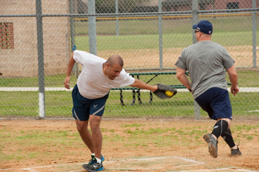 U.S. Air Force Chief Master Sgt. Manuel Camacho, 23d Security Forces Squadron, attempts to force an out on Col. Michael Ross, 820th Base Defense Group commander, during the annual Eagles versus Chiefs softball game March 13, 2015, at Moody Air Force Base, Ga. The Eagles team, composed of base commanders, and Chiefs team, composed of base chief master sergeants, play a friendly game of soft ball every year. (U.S. Air Force photo by Staff Sgt. Eric Summers Jr./Released)