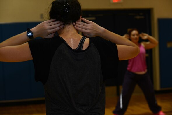 Esther Oswald, wife of U.S. Air Force Airman 1st Class Zachary Oswald, follows the lead of Katrina McReynolds, Zumba instructor, during the Zombie Zumba event March 13, 2015, at Moody Air Force Base, Ga. Participants combined fun and fitness during this event. (U.S. Air Force photo by Airman 1st Class Kathleen D. Bryant/Released)
