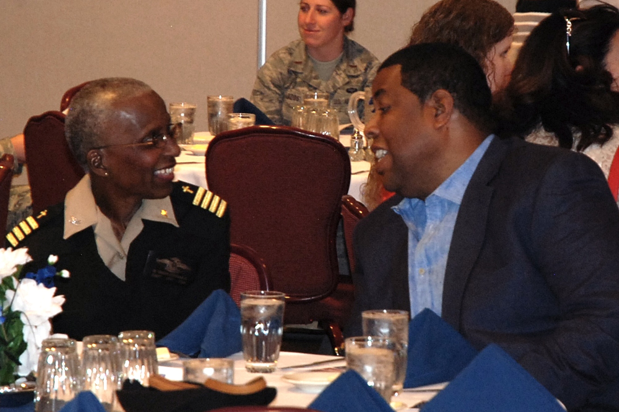 PETERSON AIR FORCE BASE, Colo. -- Chip Simmons, founder and president of After the Game Ministries and chaplain for the Denver Broncos, chats with Navy Chaplain (Capt.) Brenda Bradley-Davila, NORAD/NORTHCOM Command chaplain, before delivering his talk during the National Prayer Luncheon March 11 at The Club. (U.S. Air Force photo by Dave Smith)