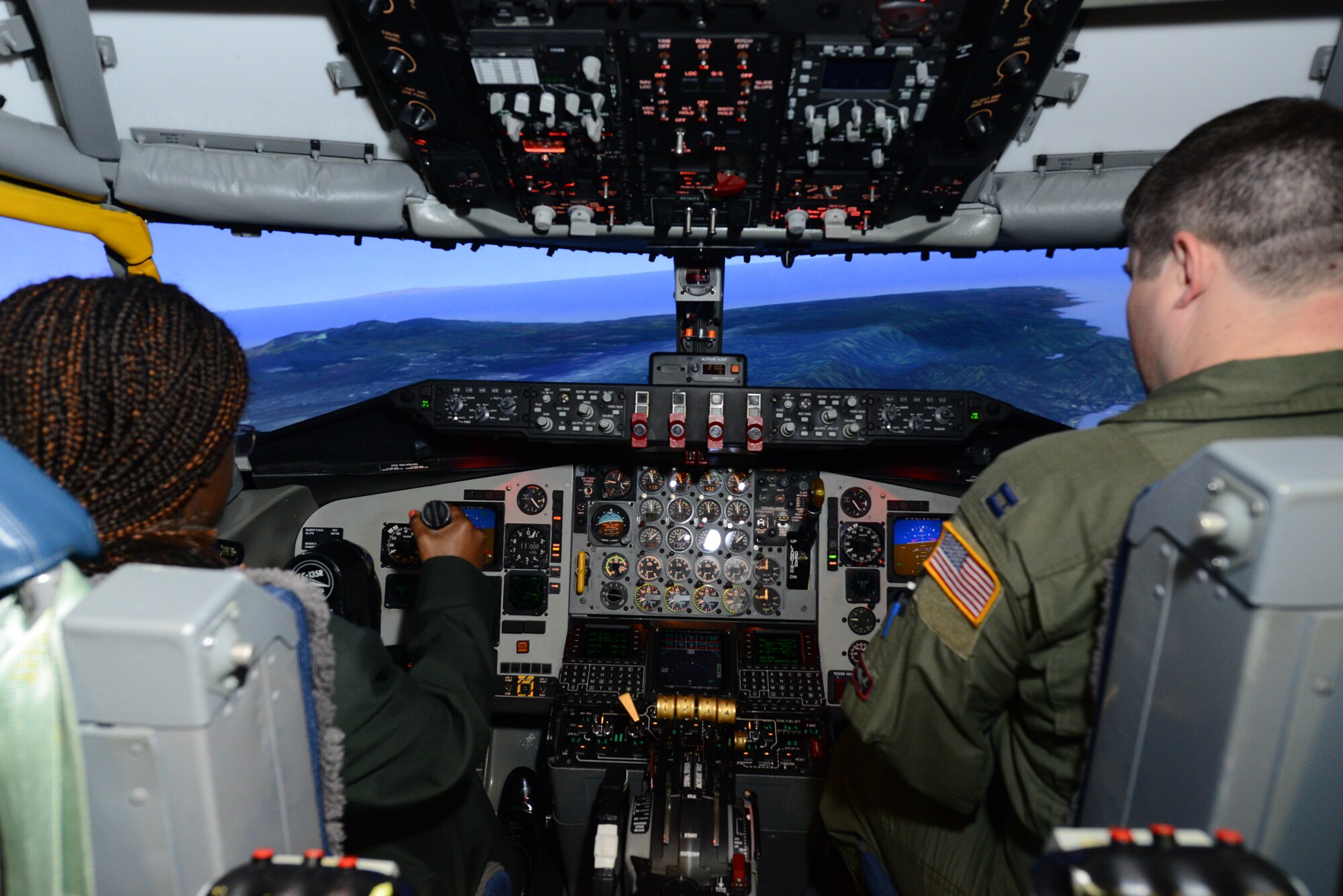 Capt. Daniel Pocock, 384th Air Refueling Squadron pilot, explains to January Reed, Sowers High School Junior ROTC cadet, how fly to a KC-135R Stratotanker simulator, March 11, 2015, at McConnell Air Force Base, Kan. Cadets from local schools visited different squadrons around base and performed hands-on simulated tasks. (U.S. Air Force photo by Airman 1st Class Christopher Thornbury)