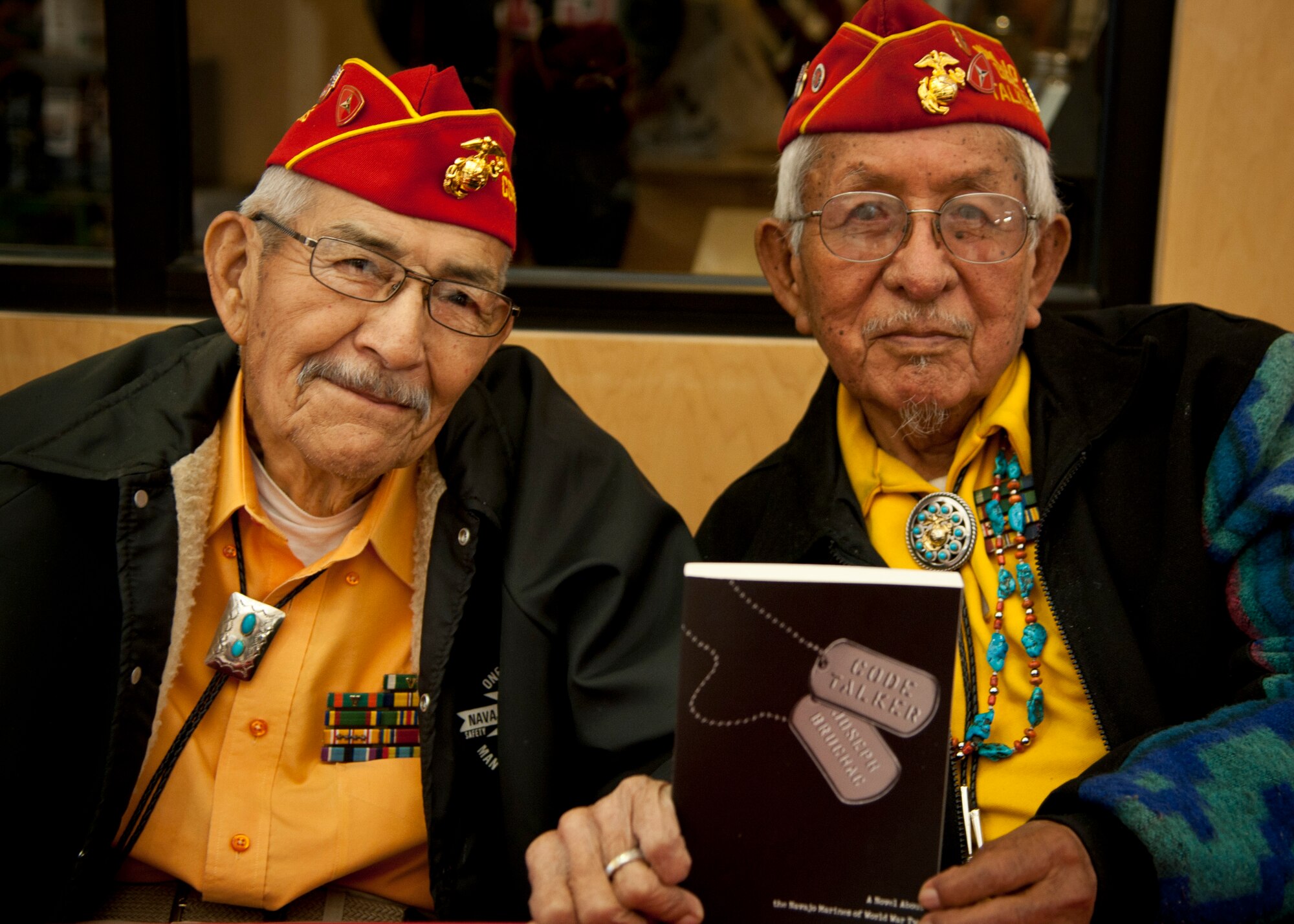 PETERSON AIR FORCE BASE, Colo. -- Alfred Newman (left) and Bill Toledo (right), former Marine Navajo Code Talkers, pose for a photo during a fundraising event at the Peterson AFB Base Exchange March 12. Of the more than 400 original Code Talkers who served during World War II, Newman and Toledo are two of 20 still alive today. The Navajo language had few words for military equipment, so Code Talkers often described aircraft as different types of birds and ships as different types of fish. (U.S. Air Force photo by Staff Sgt. J. Aaron Breeden)