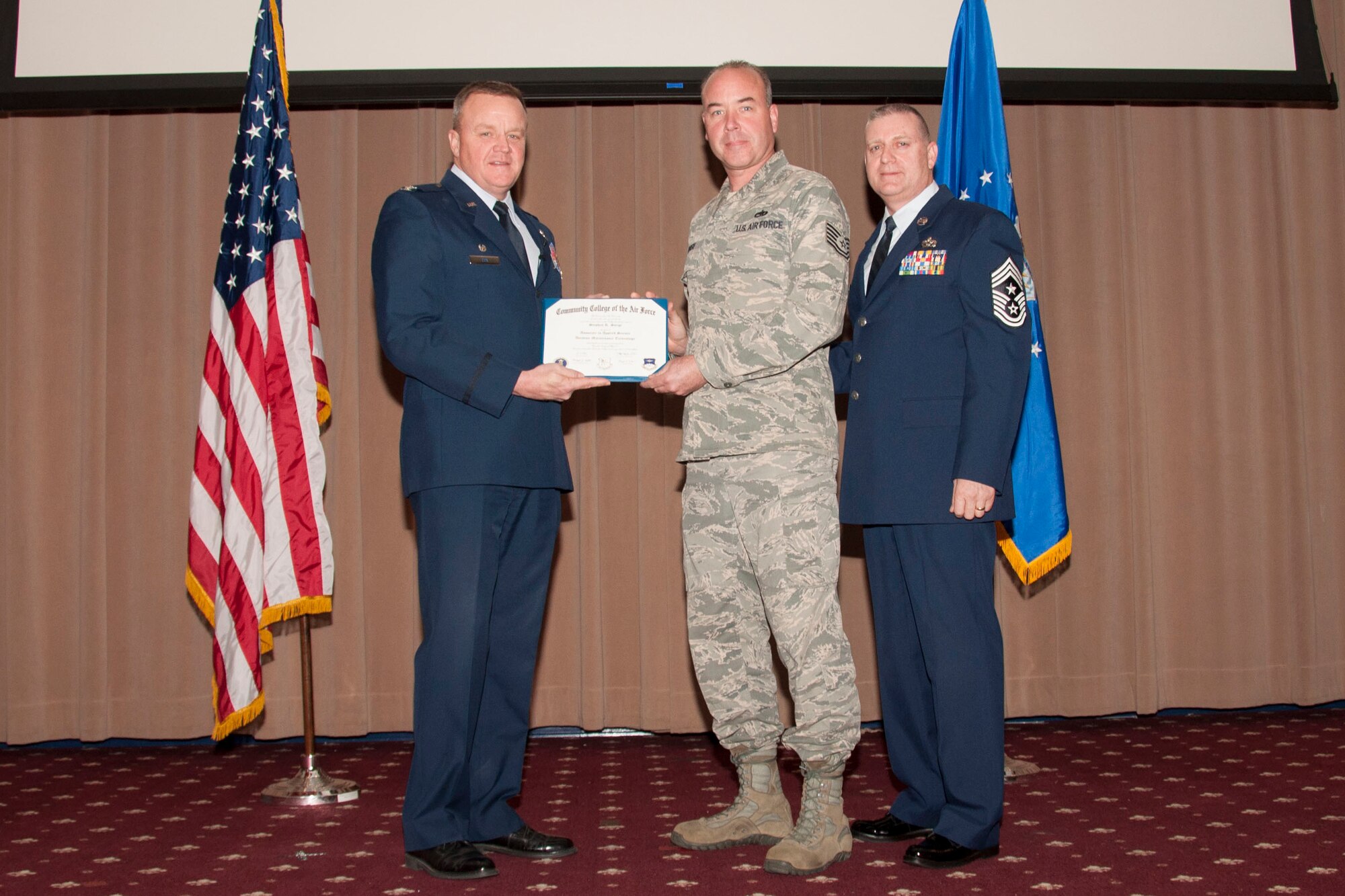 U.S. Air Force Col. Bruce Cox, 307th Bomb Wing commander, presents TSgt Stephen Sorge, 307th Maintenance Squadron his degree from the Community College of the Air Force in Aviation Maintenance Technology, March 8, 2015, Barksdale Air Force Base, La. (U.S. Air Force photo by Tech. Sgt. Theodore Daigle/Released)