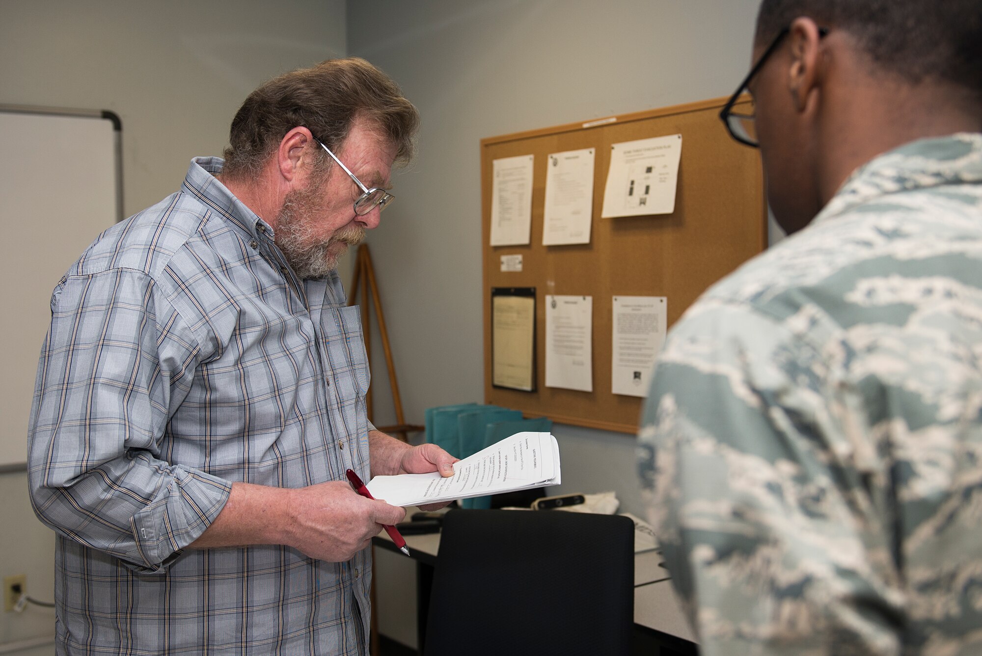 Harold Green, 364th Training Squadron instructor, reviews an assignment from U.S. Air Force Airman Treyton-Thomas Juopperi, 364th TRS student, at Sheppard Air Force Base, Texas, March 16, 2015. Juopperi finished his last day of block 2, which trains Airmen how to fill out proper forms in their career field. He is estimated to graduate in June, 2015. (U.S. Air Force photo by Senior Airman Kyle Gese)