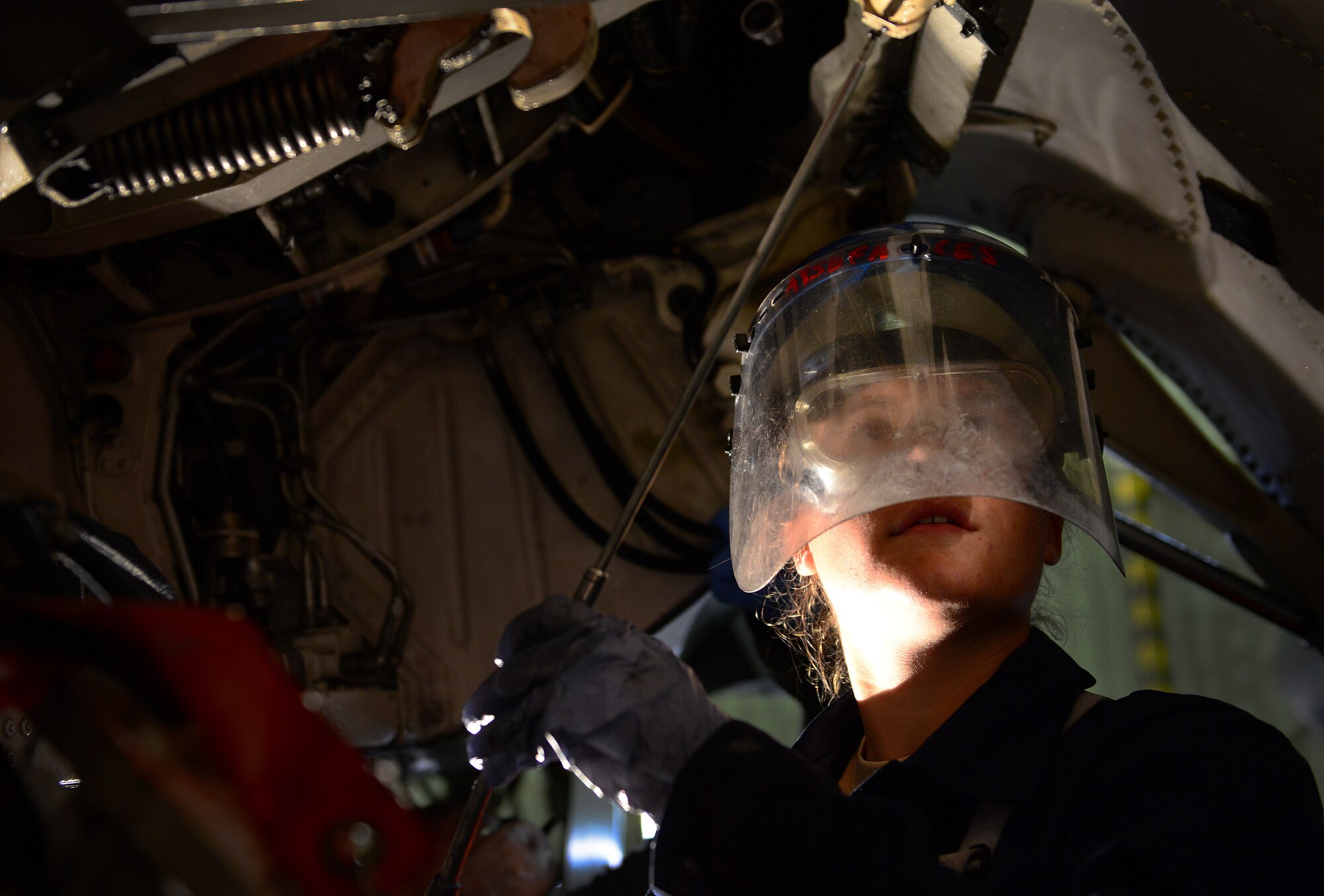 U.S. Air Force Airman 1st Class Heather Dienes, 31st Aircraft Maintenance Squadron crew chief, lubes a pivot point underneath an F-16 Fighting Falcon after washing the aircraft, March 17, 2015, at Aviano Air Base, Italy. To assist with crew chiefs’ frequent inspections, Aviano aircraft receive a thorough cleaning using soap, water and lube every 180 days. (U.S. Air Force photo by Senior Airman Matthew Lotz/Released)