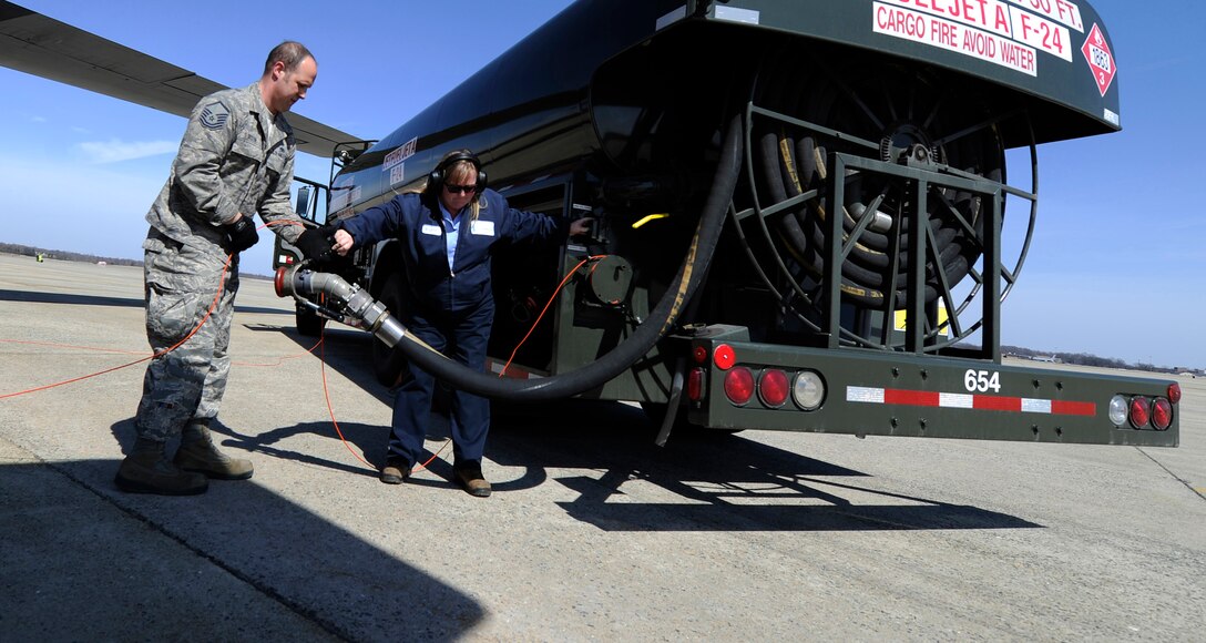 Master Sgt. Chris Sutton, 166th Airlift Wing crew chief and Kristen Huffman, Akima Technological Solutions fuels distribution system operator, reel a gas hose after refueling an aircraft on the Joint Base Andrews flightline, Maryland, March 16, 2015. Akima services the 11th Wing, 89th Airlift Wing, Naval Air Facility Washington and the 459th Air Refueling Wing aircrafts around the clock. (U.S. Air Force photo/Senior Airman Nesha Humes)