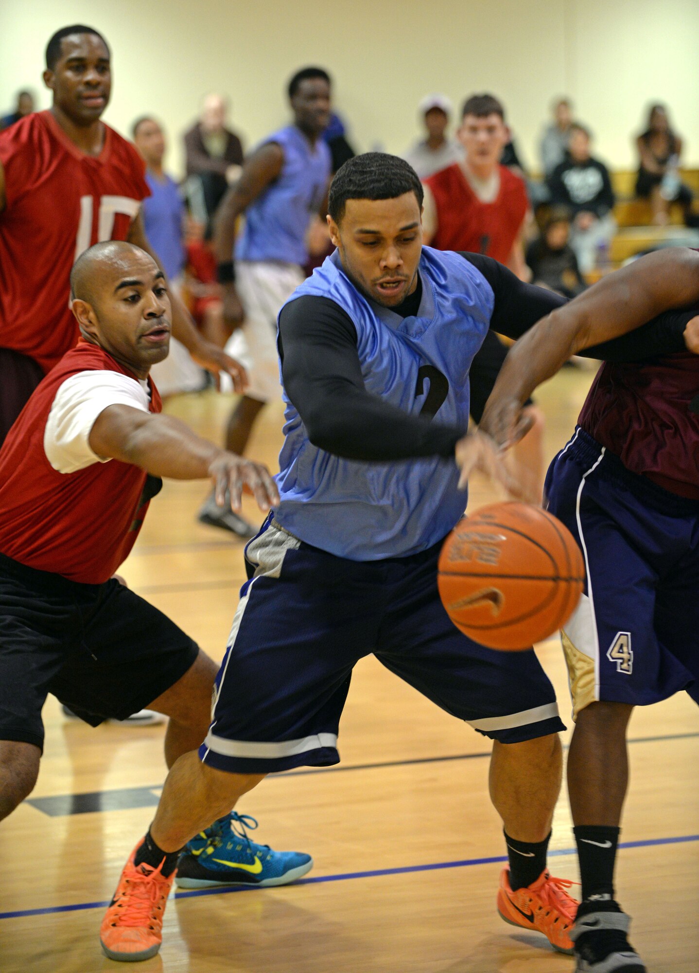 U.S. Air Force Staff Sgt. Rodney Martin, center, 100th Civil Engineer Squadron water and fuels systems maintenance craftsman, battles for the ball against players from 100th Logistics Readiness Squadron March 12, 2015, during a basketball championship game held at the Hardstand Fitness Center, on RAF Mildenhall, England. The 100th CES was champion to the 100th LRS with a final score of 67-53. (U.S. Air Force photo by Senior Airman Christine Griffiths/Released)