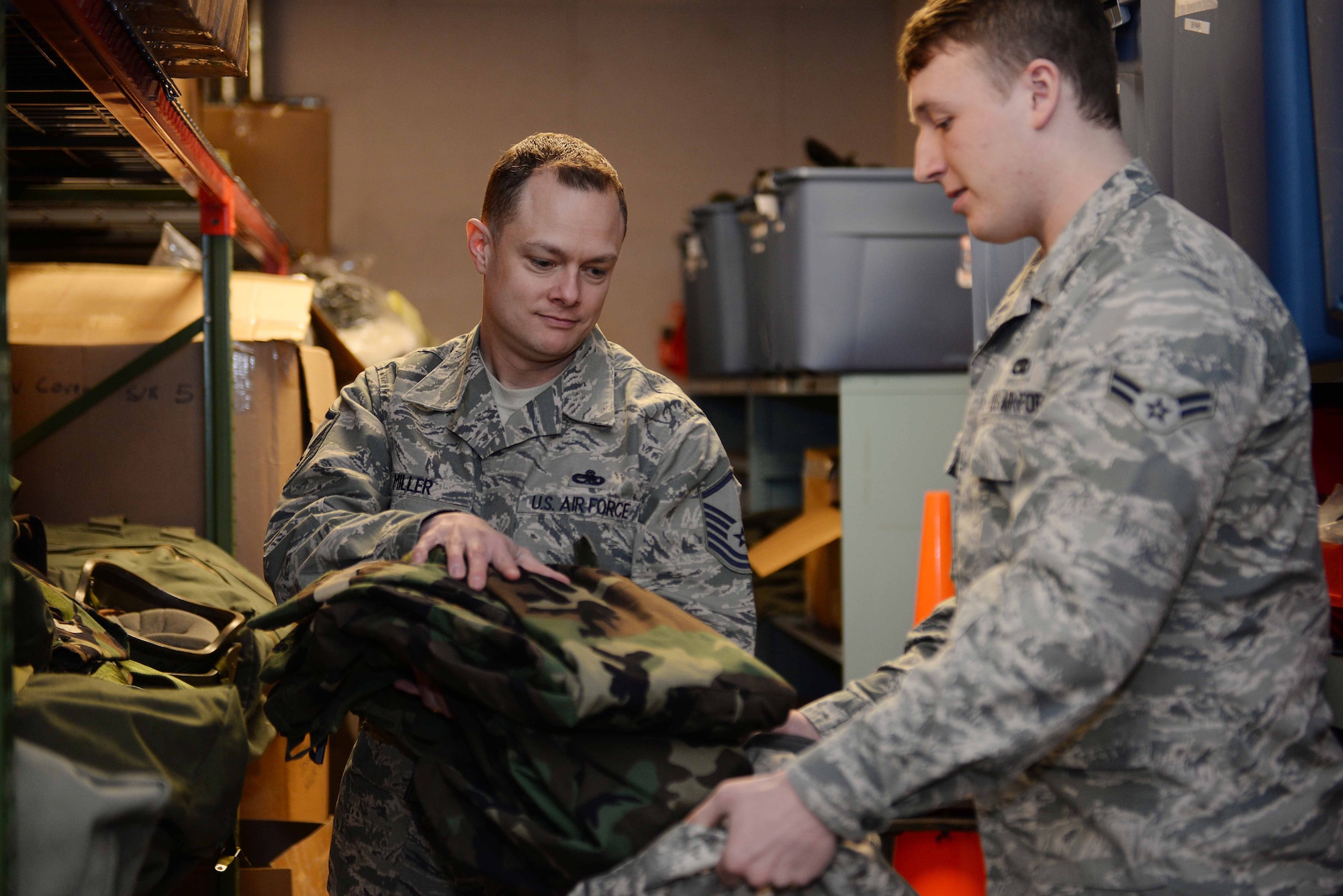 Master Sgt. Matthew Miller, 28th Maintenance Squadron unit deployment manager, issues Airman 1st Class Matthew Gallagher, 28th MXS avionics test station technician, chemical environment training gear at Ellsworth Air Force Base, S.D., March 4, 2015. Prior to deployments and base exercises, Ellsworth’s UDMs ensure Airmen are outfitted with gear to operate in a simulated chemical environment. (U.S. Air Force photo by Airman 1st Class Rebecca Imwalle/Released) 