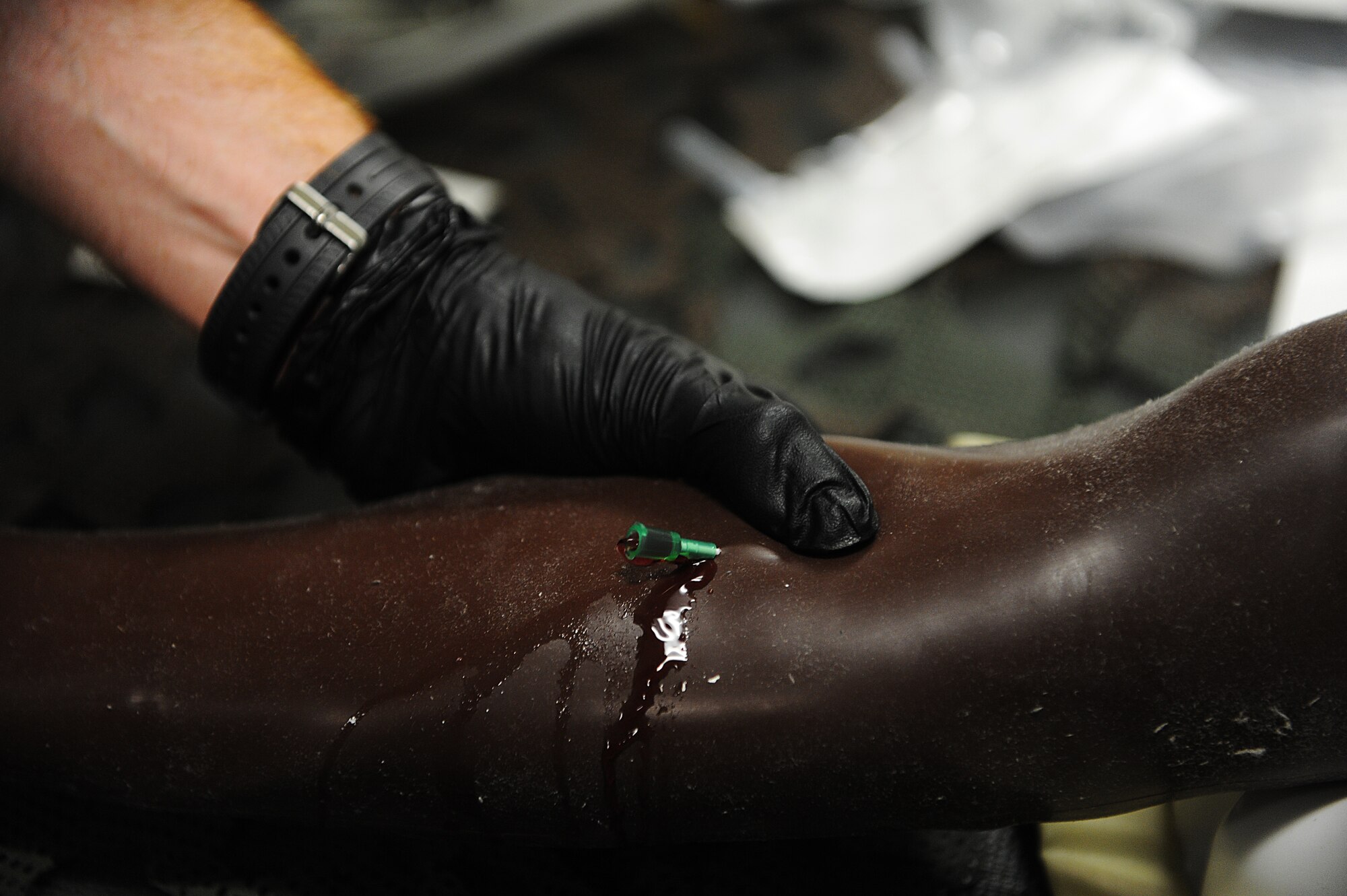 Fake blood flows from a mannequin arm during intravenous therapy training on Kadena Air Base, Japan, March 4, 2015. Intravenous therapy can be used to correct electrolyte imbalances, to deliver medications, for blood transfusion or fluid replacement. (U.S. Air Force photo by Airman 1st Class Stephen G. Eigel)