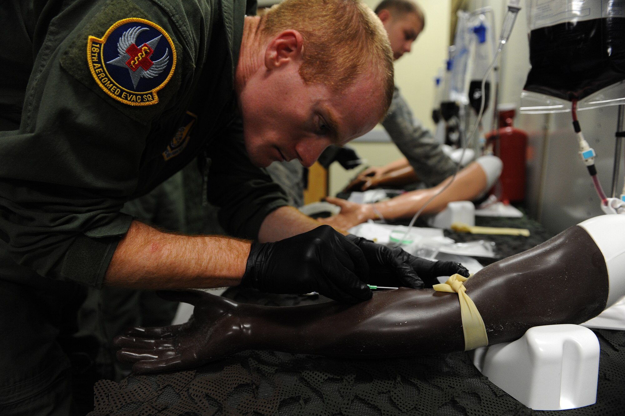 U.S. Air Force Staff Sgt. Joel Pallon, 18th Aeromedical Evacuation Squadron air evacuation medic, inserts a needle into a mannequin arm to practice intravenous therapy on Kadena Air Base, Japan, March 4, 2015. Intravenous therapy is one of the most common medical practices used to correct electrolyte imbalances, to deliver medications, for blood transfusion or fluid replacement. (U.S. Air Force photo by Airman 1st Class Stephen G. Eigel)