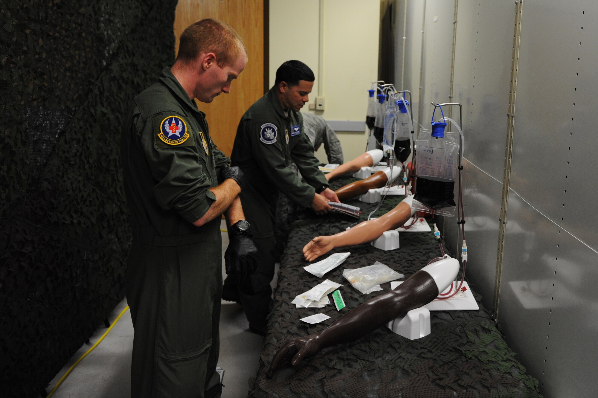 Members of the 18th Aeromedical Evacuation Squadron prepare to practice intravenous therapy on mannequin arms on Kadena Air Base, Japan, March 4, 2015. The 18th AES has recently built a one-of-a-kind training center that can be used for multiple medical services. (U.S. Air Force photo by Airman 1st Class Stephen G. Eigel)