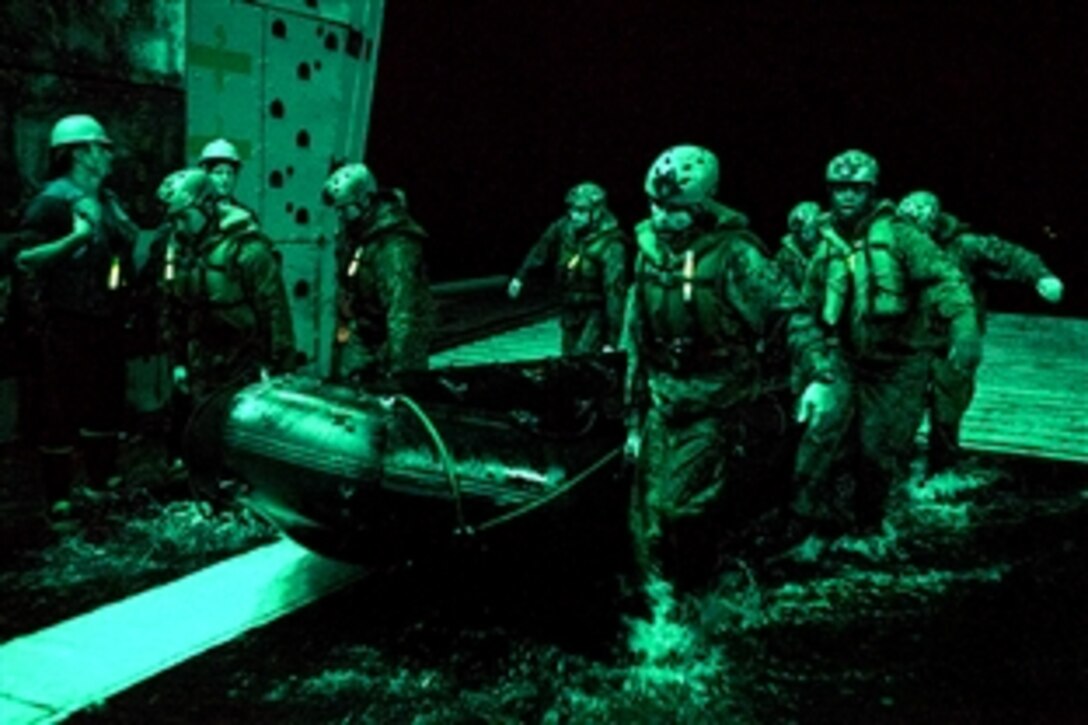 U.S. Marines conduct an exercise using a combat rubber raiding craft as part of amphibious training aboard the USS Green Bay in the Asia-Pacific region, March 11, 2015. The green cast reflects night lighting from the ship's well deck. The Marines are assigned to the 31st Marine Expeditionary Unit.
