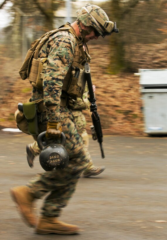 U.S. Marine Cpl. Steven Carter, an infantryman with Special-Purpose Marine Air-Ground Task Force Crisis Response-Africa sprints with two 36-kilogram weights during a combat efficiency test in Baumholder, Germany, March 10, 2015. U.S. Army Special Forces created a series of mentally and physically challenging tasks designed to test the Marines’ abilities to complete combat operations in an urban environment. (U.S. Marine Corps photo by Sgt. Paul Peterson/Released)