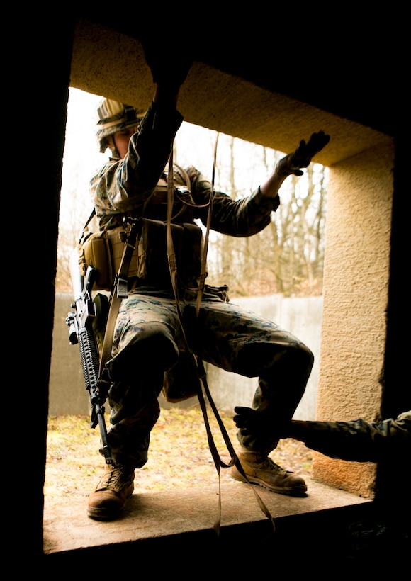 A U.S. Marine with Special-Purpose Marine Air-Ground Task Force Crisis Response-Africa climbs into a window during a combat efficiency test in Baumholder, Germany, March 10, 2015. The Marines completed a series of physically demanding obstacles prepared by U.S. Army Special Forces to test the service members’ mental flexibility and physical strength. (U.S. Marine Corps photo by Sgt. Paul Peterson/Released)