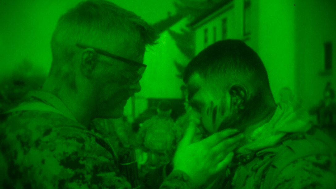 A U.S. Marine with Special-Purpose Marine Air-Ground Task Force Crisis Response-Africa dons camouflage paint before embarking on a joint night raid during training with Army Special Forces in Baumholder, Germany, March 11, 2015. The Marines slipped into a block of buildings under the cover of darkness and established a foothold for a precision strike by Special Forces personnel. 
