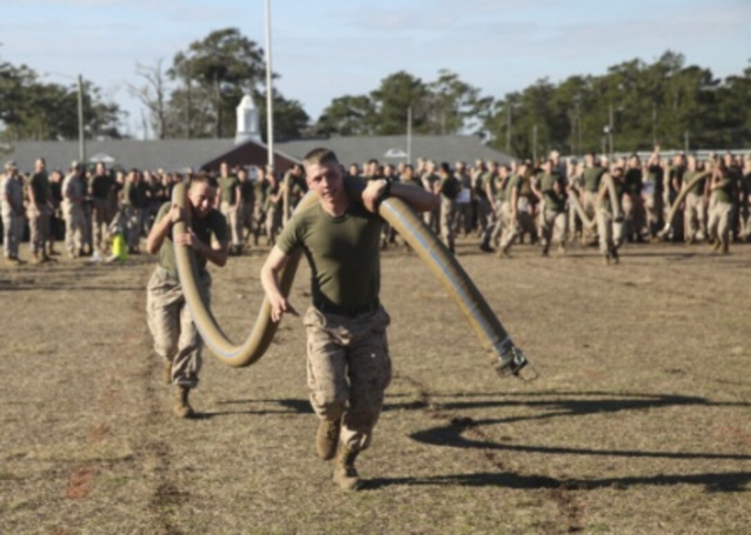 Two Marine Corps engineers carry a water hose that weighs approximately 130 pounds in a relay competition during the annual St. Patrick’s Day Engineer Field Meet, March 12, 2015, on Ellis Field at Courthouse Bay aboard Marine Corps Base Camp Lejeune, N.C. Engineers from across Camp Lejeune and New River Air Station came together to compete in 15 engineer-themed events in honor of the patron saint of engineers, St. Patrick. (U.S. Marine Corps photo by Cpl Michelle Reif/released)