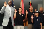 Basketball legend Michael Jordan, left, and members of his motorcycle racing team take the Oath of Allegiance to the National Guard during an event at the Army National Guard Readiness Center in Arlington, Va., Monday, June 28, 2010. The Guard is a sponsor of two riders that race for Jordan, Jake Zemke and Aaron Yates.