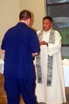 Lt. Col. Caesar A. Silva, a chaplain for the Louisiana Air National Guard, serves communion to a Coast Guard oil spill responder at a Catholic Mass held at the Deepwater Horizon Unified Command in Robert, La., May 30, 2010. Louisiana National Guard chaplains and chaplains' assistants provide worship and counseling services regardless of religious affiliation or belief.