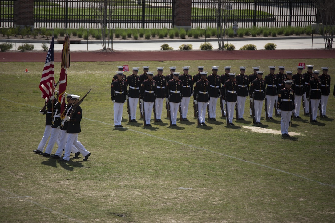 The Marine Corps Silent Drill Platoon stands at attention while the color guard marches by during a Battle Colors Ceremony at Marine Corps Support Facility New Orleans, March 17, 2015. Marines from Marine Forces Reserve watched the performance while the 24-man platoon executed flawless drill movements. 