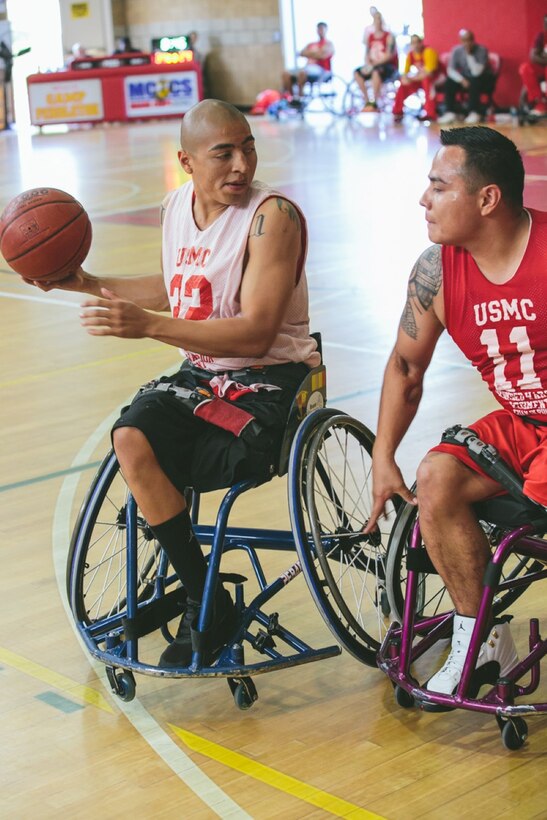 Veteran Cpl Josue Barron of Cudahy, CA, maneuvers around the defense of Cpl Marcus Chischilly of Phoenix, AZ in the wheelchair basketball competition. The Marine Corps Trials are a Paralympic style competition in which wounded, ill, and injured Marines, Marine Veterans, and international allies compete in archery, cycling, field, shooting, sitting volleyball, swimming, track, and wheelchair basketball. The 2014 Marine Corps Trials are held aboard Camp Pendleton, Calif. from March 4-12.