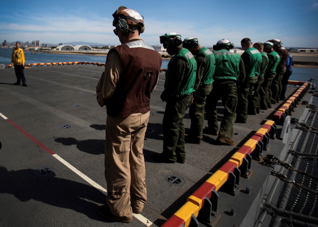 U.S. Marines and Sailors perform a foreign object damage walk on the flight deck of the USS Essex (LHD 2) during Composite Training Unit Exercise (COMPTUEX) aboard Naval Base San Diego March 16, 2015. FOD walks are performed on multiple occasions to clear the flight deck of any rocks and debris that could interfere with flight operations. (U.S. Marine Corps photo by Cpl. Elize McKelvey/Released)