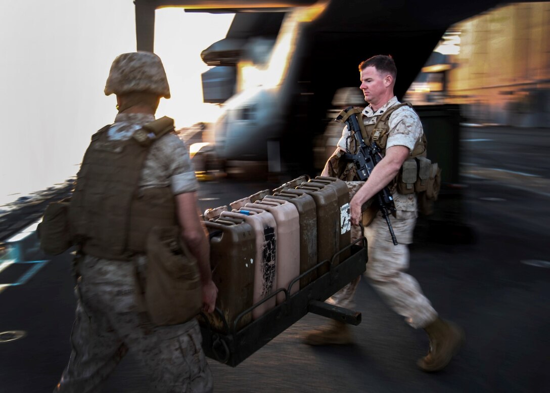 U.S. Marines with India Battery, Battalion Landing Team 3rd Battalion, 1st Marine Regiment, 15th Marine Expeditionary Unit, move water jugs to clear room on the flight deck of the USS Essex (LDH 2) during Composite Training Unit Exercise (COMPTUEX) aboard Naval Base San Diego March 17, 2015. The 15th MEU is embarked aboard the three ships of the Essex Amphibious Ready Group – the USS Essex, USS Anchorage (LPD 23), and USS Rushmore (LSD 47) – during COMPTUEX to continue integrating and training with the PHIBRON and ship staffs as they prepare for deployment later this spring. (U.S. Marine Corps photo by Cpl. Elize McKelvey/Released)