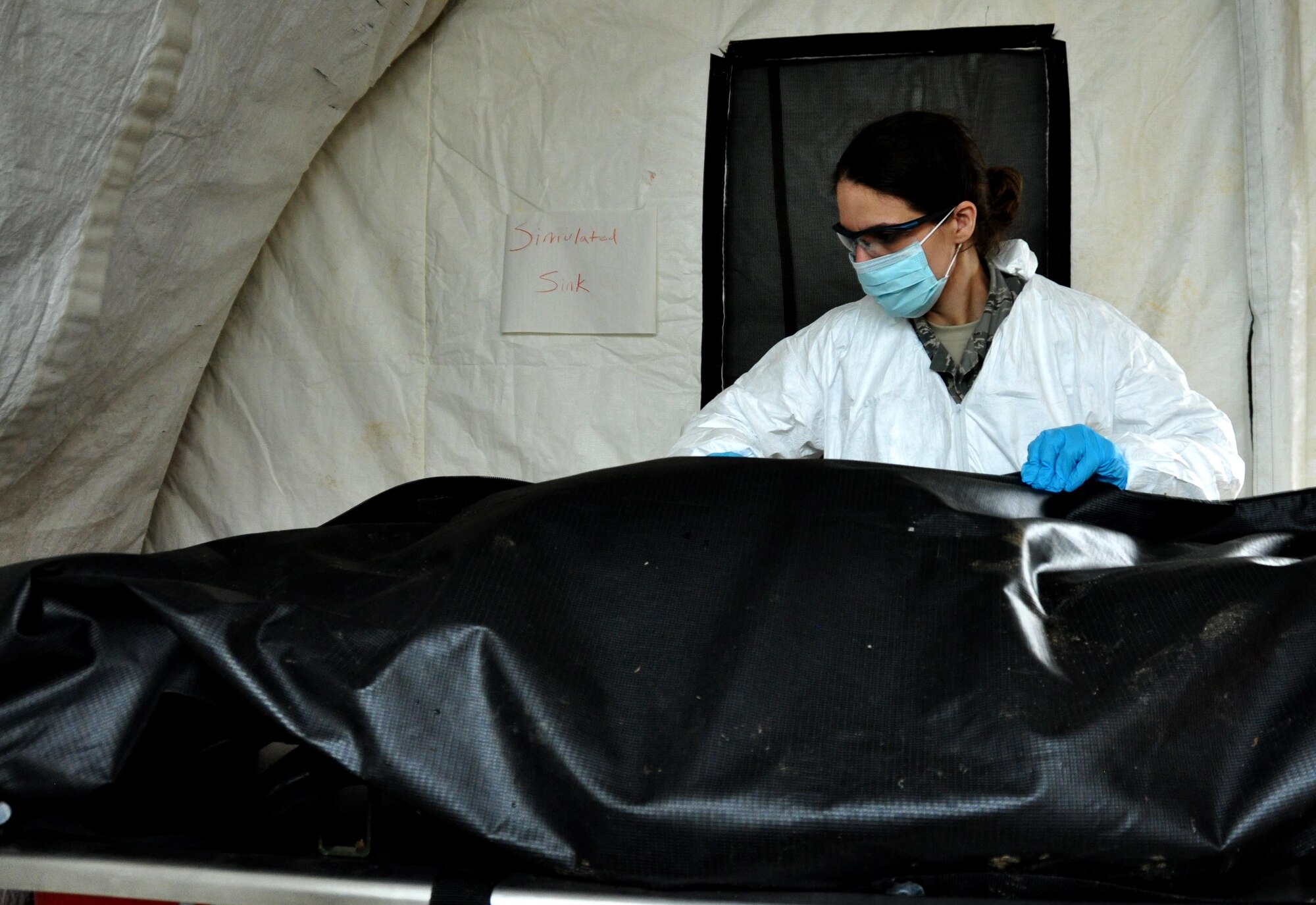 Master Sgt. Nikole Zottola, 911th Force Support Squadron, Pittsburgh, Pa., inspects a casualty dummy during OPERATION Everybody Panic as part of Force Support Silver Flag at Dobbins Air Reserve Base, Ga., March 10, 2015. The challenge consisted of teams competing against each other in nine different events ranging from following a convoy, building tents, fixing Babington burners, cooking meals, planning lodging, planning a base from scratch, driving a forklift and a scavenger hunt. (U.S. Air Force photo/Senior Airman Daniel Phelps)