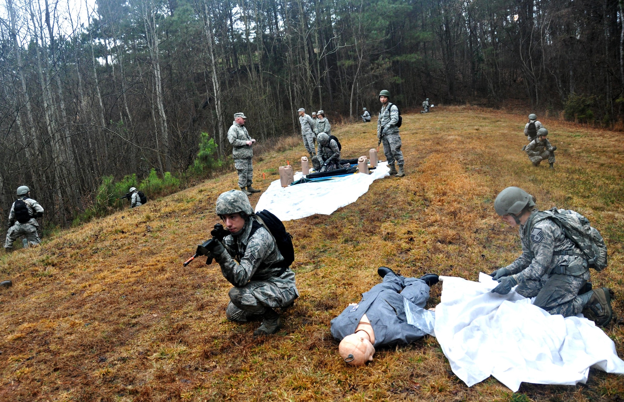 Airmen from the 911th Force Support Squadron, Pittsburgh, Pa., react to an attack during OPERATION Everybody Panic as part of Force Support Silver Flag at Dobbins Air Reserve Base, Ga., March 10, 2015. Teams were tasked with engaging targets, self-aid buddy care, providing care under fire, identifying unexploded ordnances and improvised explosive devices, describing and providing the location of the UXOs and IEDs on a grid, low and high crawling, and transporting remains during this scenario. (U.S. Air Force photo/Senior Airman Daniel Phelps)