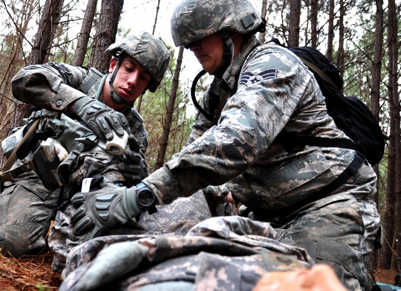 Senior Airmen Tyler Wright and Ashley Coffin, 911th Force Support Squadron, Pittsburgh, Pa., perform self-aid buddy care on a casualty dummy with a lost limb during OPERATION Everybody Panic as part of Force Support Silver Flag at Dobbins Air Reserve Base, Ga., March 10, 2015. Teams were tasked with engaging targets, self-aid buddy care, providing care under fire, identifying unexploded ordnances and improvised explosive devices, describing and providing the location of the UXOs and IEDs on a grid, low and high crawling, and transporting remains during this scenario. (U.S. Air Force photo/Senior Airman Daniel Phelps)