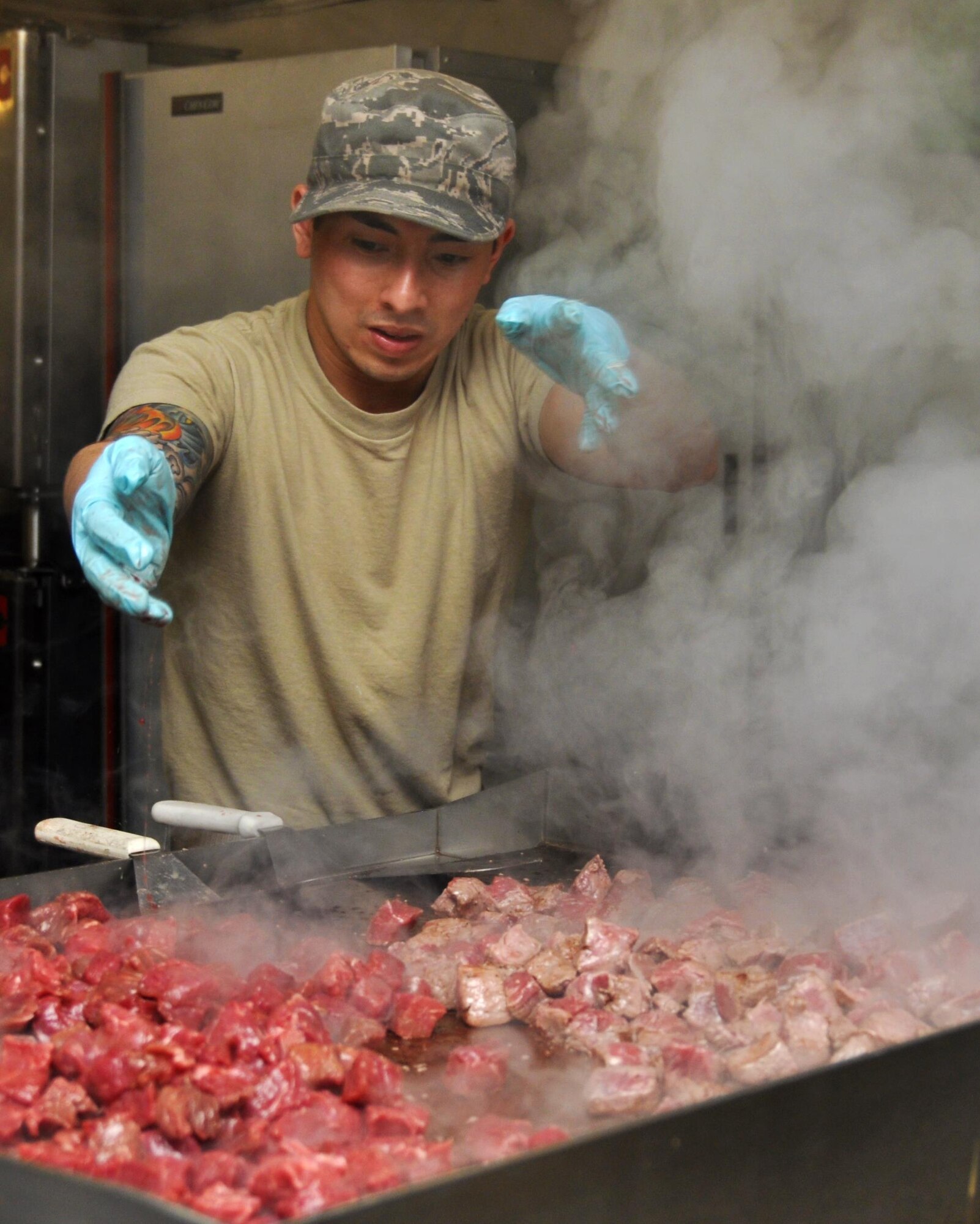 Senior Airman Fa Pham, 911th Force Support Squadron, Pittsburgh, Pa., throws beef on the grill to make Hungarian Beef during the Readiness Challenge for Force Support Silver Flag at Dobbins Air Reserve Base, Georgia, March 11, 2015. The challenge consisted of teams competing against each other in nine different events ranging from following a convoy, building tents, fixing Babington burners, cooking meals, planning lodging, planning a base from scratch, driving a forklift and a scavenger hunt.  (U.S. Air Force photo/Senior Airman Daniel Phelps)