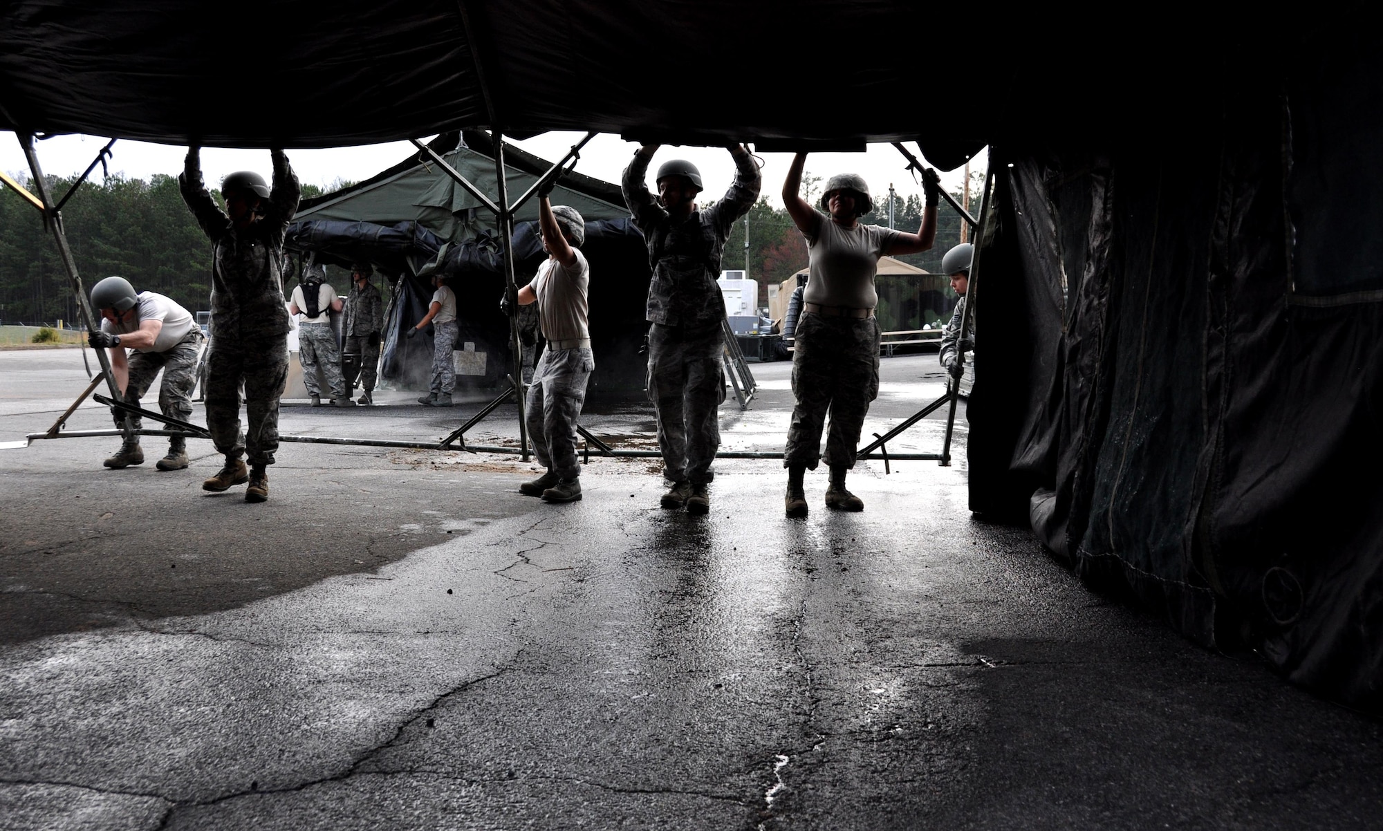 Airmen from the 911th Force Support Squadron, Pittsburgh, Pa. lift up a field kitchen tent during the Readiness Challenge for Force Support Silver Flag at Dobbins Air Reserve Base, Georgia, March 12, 2015. The challenge consisted of teams competing against each other in nine different events ranging from following a convoy, building tents, fixing Babington burners, cooking meals, planning lodging, planning a base from scratch, driving a forklift and a scavenger hunt.  (U.S. Air Force photo/Senior Airman Daniel Phelps)