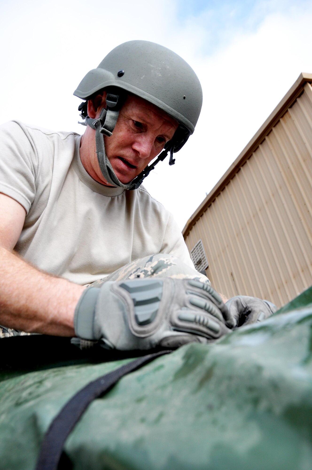 Master Sgt. Mark Ansani, 911th Force Support Squadron, Pittsburgh, Pa., unties bag containing poles for a tent during the Readiness Challenge for Force Support Silver Flag at Dobbins Air Reserve Base, Georgia, March 12, 2015. The challenge consisted of teams competing against each other in nine different events ranging from following a convoy, building tents, fixing Babington burners, cooking meals, planning lodging, planning a base from scratch, driving a forklift and a scavenger hunt. (U.S. Air Force photo/Senior Airman Daniel Phelps)